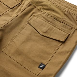 Roark Layover Pro Traveler Pants in Dark Khaki, straight-leg 4-way stretch Embarq Dura-Stretch fabric with TSA-friendly waistband, zippered travel pockets, back phone stash pocket, and laser-perforated cooling panel