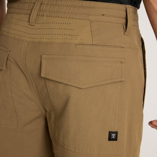 Roark Layover Pro Traveler Pants in Dark Khaki, straight-leg 4-way stretch Embarq Dura-Stretch fabric with TSA-friendly waistband, zippered travel pockets, back phone stash pocket, and laser-perforated cooling panel