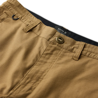 Roark Layover Pro Traveler Pants in Dark Khaki, straight-leg 4-way stretch Embarq Dura-Stretch fabric with TSA-friendly waistband, zippered travel pockets, back phone stash pocket, and laser-perforated cooling panel