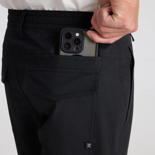 Close-up of black Roark pants showing rear pockets and a phone storage pocket.