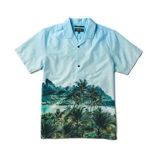 Model showcasing the Roark Gonzo Camp Collar Shirt - Hinano Otemanu Light Blue, a Tahiti-inspired piece made from an organic cotton and Tencel blend. This relaxed fit shirt embodies the serene beauty of Bora Bora's Otemanu peak.