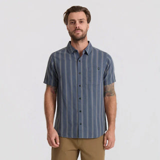 Roark Crosswinds Button Up Shirt in Neptune with blue-grey vertical dobby stripes, short sleeves, a button-front closure, and chest pocket