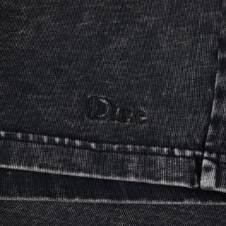Close-up of black denim fabric with 'Dine' branding.