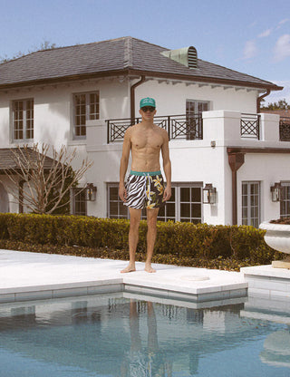 Man standing on a pool deck in front of a house