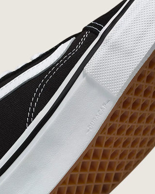 Close-up of a black and white sneaker with a focus on the sole and brand logo.
