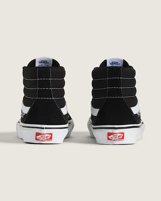 Black and white high-top sneakers with red and white label on a light gray background