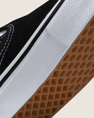 Close-up of a black and white sneaker with brown sole on a light background