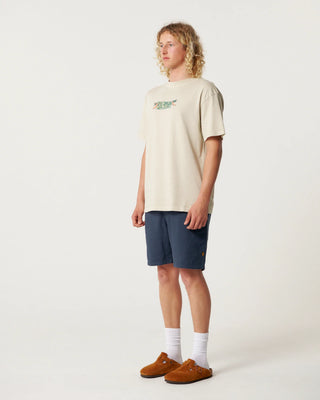 Person wearing a beige t-shirt and navy shorts on a white background