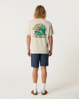 Person wearing a beige t-shirt with a graphic design and text, standing against a white background