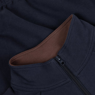 Close-up of a navy blue jacket with a brown lining inside a pocket.