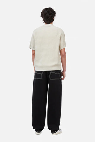 Person wearing a white t-shirt and black pants on a white background