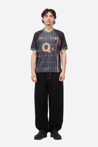 Person wearing a dark patterned shirt with 'Q4' logo on a white background