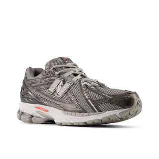 New Balance 1906R lifestyle sneaker in black metallic and urgent red with heel pods, cushioned midsole, and arched overlays.