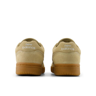 Beige New Balance sneakers shown from the back on a white background
