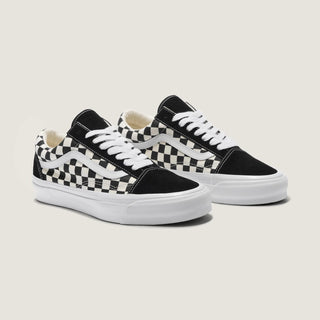 Black and white Vans Old Skool shoes with checkerboard canvas, suede overlays, white Sidestripe, and white rubber outsole.