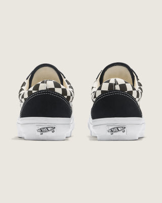 Black and white Vans Old Skool shoes with checkerboard canvas, suede overlays, white Sidestripe, and white rubber outsole.