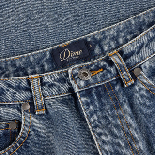 Front view of Dime Women’s Baggy Denim Pants in Indigo Washed with faded blue denim, wide legs, curved front pockets, and belt loops