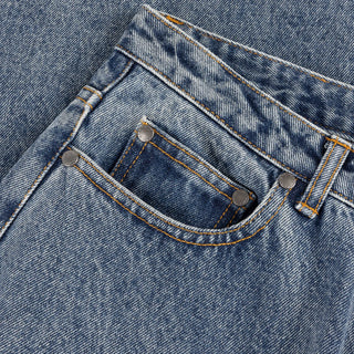 Front view of Dime Women’s Baggy Denim Pants in Indigo Washed with faded blue denim, wide legs, curved front pockets, and belt loops