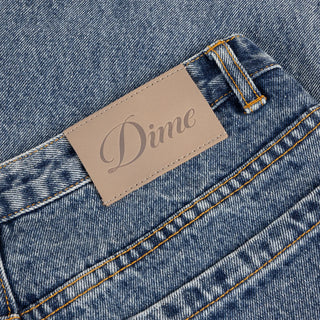 Front view of Dime Women’s Baggy Denim Pants in Indigo Washed with faded blue denim, wide legs, curved front pockets, and belt loops