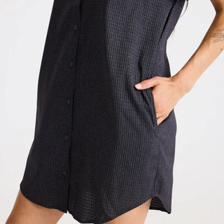 Roark Women's Bless Up Dress in Black, relaxed fit technical perforated shirt dress in 68% nylon 32% polyester with moisture-wicking quick-dry fabric, rubberized buttons, magnetic pocket closure, and leopard printed lining