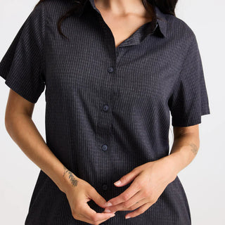 Roark Women's Bless Up Dress in Black, relaxed fit technical perforated shirt dress in 68% nylon 32% polyester with moisture-wicking quick-dry fabric, rubberized buttons, magnetic pocket closure, and leopard printed lining