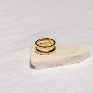 Gold sculptural ring with flowing ocean-inspired curves.