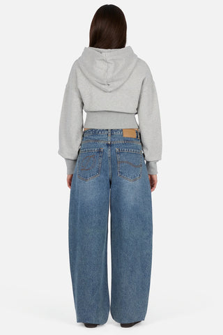 Front view of Dime Women’s Baggy Denim Pants in Indigo Washed with faded blue denim, wide legs, curved front pockets, and belt loops