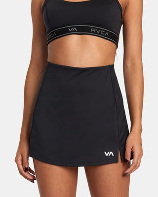 Woman in RVCA VA Essential Tennis Skirt, high-rise, moisture-wicking fabric