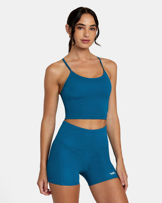 Active woman enjoying her workout in the RVCA VA Sport Base Tank Sports Bra, showcasing the scoop neck, racerback design, and the trendy half-moon cut-out at the back.