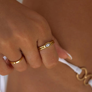 ALCO Lila ring in 18K gold-plated stainless steel with acrylic bead featuring crushed pearl coating for coastal elegance.