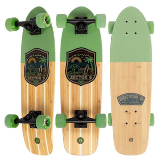 “Sector 9 Bambino Bivy complete skateboard with natural bamboo finish, green nose and wheels, black trucks, and beach camping badge artwork.”