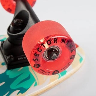 “Sector 9 Bambino Shorebreak complete skateboard with turquoise wave and lifeguard tower artwork, red wheels, black trucks, and a natural bamboo top.”