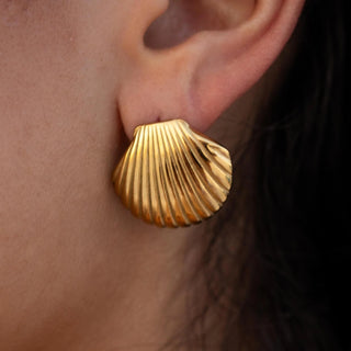 Gold earrings with minimalist sculptural design and smooth polished surface, secured with push back closure.