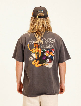 Back view of a model wearing the Duvin Rack Em Tee in washed black with a Beach Club Billiards graphic featuring a retro woman and colorful pool balls