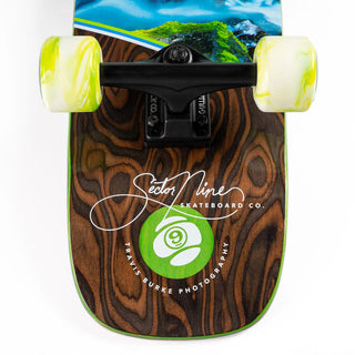 “Sector 9 Cascade Ninety Five complete skateboard showing mossy forest stream photography, woodgrain detailing, green-and-white wheels, and black grip tape.”