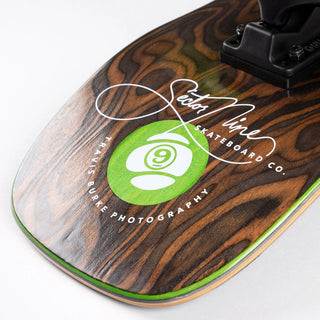 “Sector 9 Cascade Ninety Five complete skateboard showing mossy forest stream photography, woodgrain detailing, green-and-white wheels, and black grip tape.”