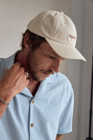 Rhythm Essential Cap in Vintage White, 100% cotton twill, six-panel, curved peak, adjustable strap, embroidered logo.