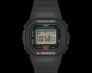 Black G-SHOCK DWN5600-1 ring watch with digital display on finger.