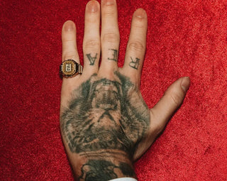 Hand with tattoos on a red background
