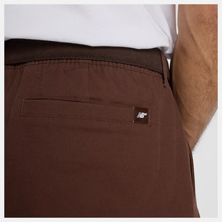 New Balance Numeric Standard Pant in Pumpernickel with lightweight cotton twill stretch fabric, straight leg, single pleat, 3-pocket design, zippered stash pocket, and elastic waistband