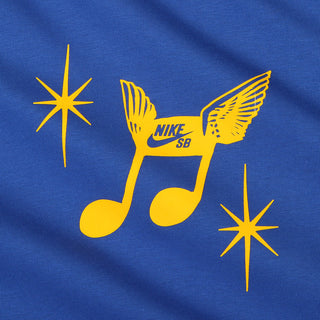 A close-up of a royal blue fabric surface featuring a yellow graphic of a winged music note with the Nike SB logo, plus two yellow starburst shapes.