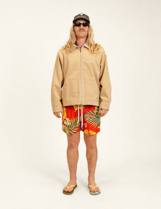 Model wearing Duvin Tropic Floral Swim Shorts in red with multicolored tropical flowers and leaves and a white drawstring