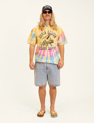 Model wearing the Duvin Leopard Tee in yellow, pink, and blue tie dye with a black leopard-and-rider graphic and Duvin Design Leisure Supply lettering