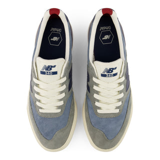 A pair of New Balance 340 sneakers shown from a top-down view. The shoes feature a color-blocked design with light blue suede, gray suede, white laces, a cream midsole, and navy blue details on the tongue and heel.