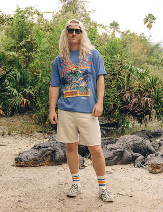 Duvin x Florida Gators Leisure Club Tee with orange Florida lettering and Albert wearing sunglasses and a Hawaiian shirt behind a Leisure Club sign.