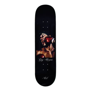 “April Guy Mariano Knockout skateboard deck with a boxing illustration, red gloves, and white script lettering on a black background.”